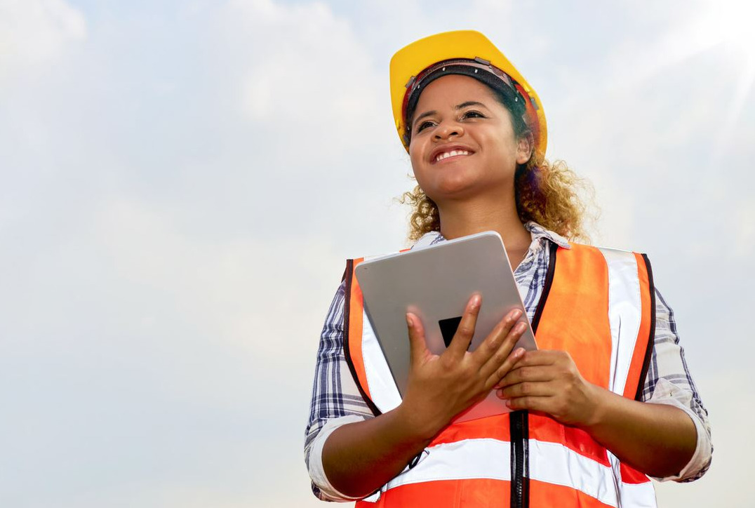 solutions sustainable construction construction worker holding a tablet with environmental site software